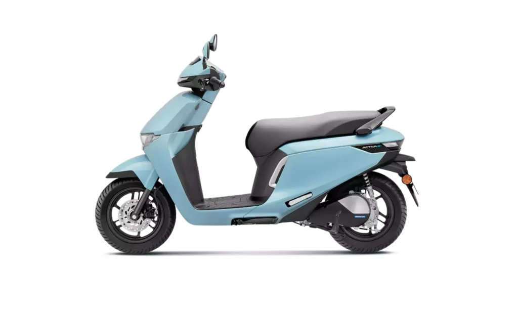 Side view of a light blue Honda Activa e electric scooter, showing its sleek body design, black seat, and wheels, set against a plain white background.