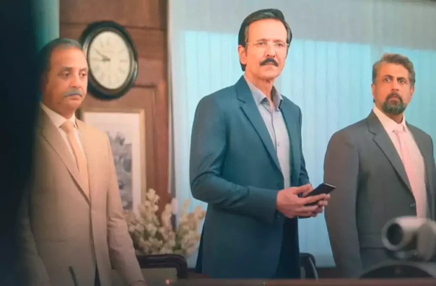 K k menon गंभीर मुद्रा में खड़े हैं स्मार्टफोन पकड़े हुए Special Ops 2 वेब सीरीज़ का एक scene